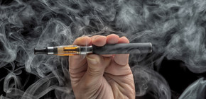 Hand holding an electronic cigarette over a dark background Un Enviado de la WVA Visita Buenos Aires con el Propósito de Legalizar los Cigarrillos Electrónicos