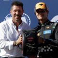 Lando Norris recibe el trofeo de la pole position de manos de Diego Simeone